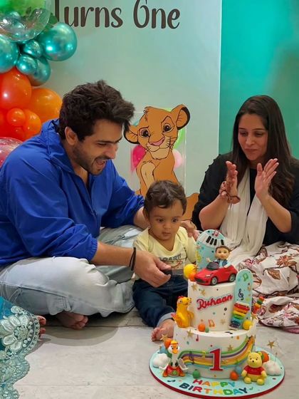 Another sweet family moment from Ruhaan's first birthday celebration. The cake features a mini car, a xylophone, and Winnie the Pooh, all made from edible materials.