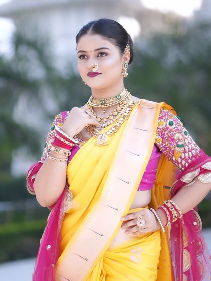 A vibrant look featuring a yellow Paithani saree with a bright pink border. The makeup is kept classic with defined eyes and a bold lip, letting the colorful outfit shine.
