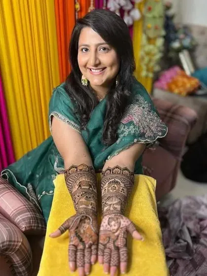 A happy bride showing her complete wedding mehandi. I designed this to include traditional elements like portraits and elephants, ensuring the art complements her festive look perfectly.