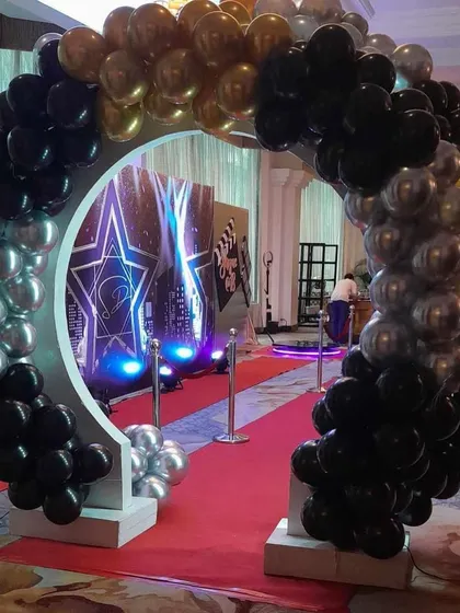 An impressive balloon arch entrance for a Hollywood-themed 18th birthday party, complete with a red carpet.