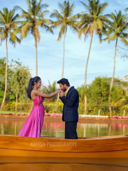 A classic romantic gesture captured on a boat, with a line of palm trees creating a beautiful, scenic backdrop for this pre-wedding shoot.