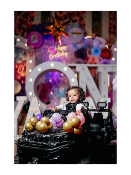 A cool partygoer in his toy jeep. This shot captures the fun and excitement of a first birthday party, complete with awesome props.