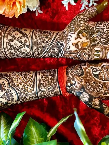 This full-arm design is a masterpiece of traditional motifs. It includes peacocks, elephants, and intricate jaali (lattice) work for a truly grand bridal statement.