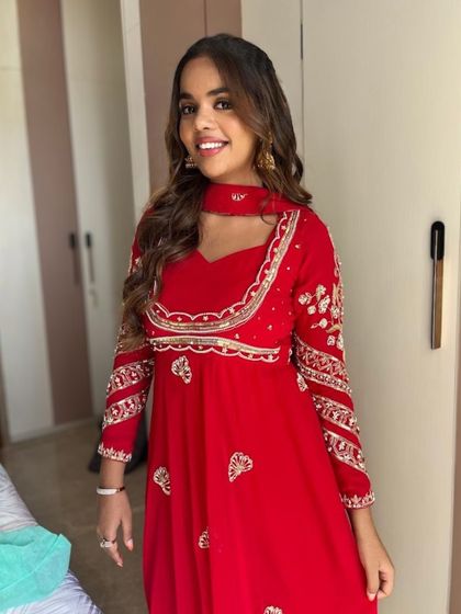A full-length view of this cheerful and festive look. The makeup is kept fresh and light to balance the heavily embroidered traditional outfit.