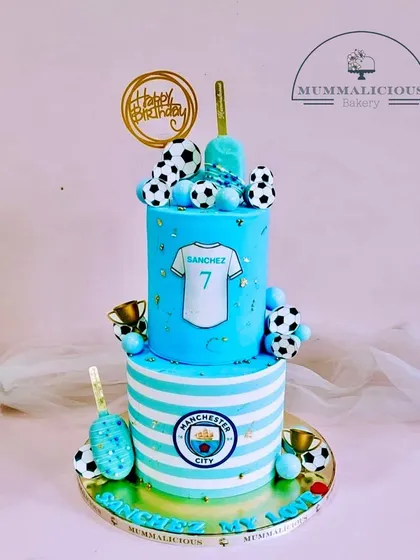 For the ultimate football fan, we designed this two-tiered Manchester City themed cake. Complete with the team crest, jersey, and edible soccer balls, it’s the perfect way to score big at a birthday celebration.