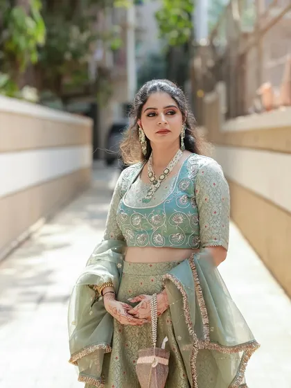 A full-length view of the elegant pastel green brocade lehenga. The A-line skirt and fitted blouse create a classic silhouette, perfect for any festive occasion.