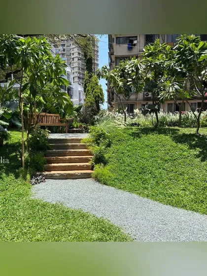 Stone steps lead up from a gravel path to a lawn. The use of natural materials and informal steps helps the hardscaping blend seamlessly with the softscape of the garden.