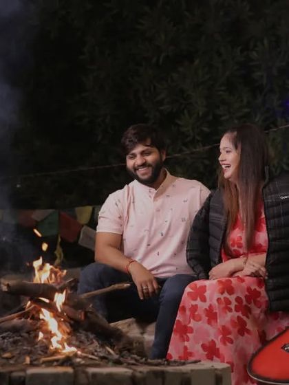 A cozy and romantic pre-wedding scene by the bonfire. The warm glow of the fire and the intimate setting make for a perfect shot that feels natural and heartfelt.