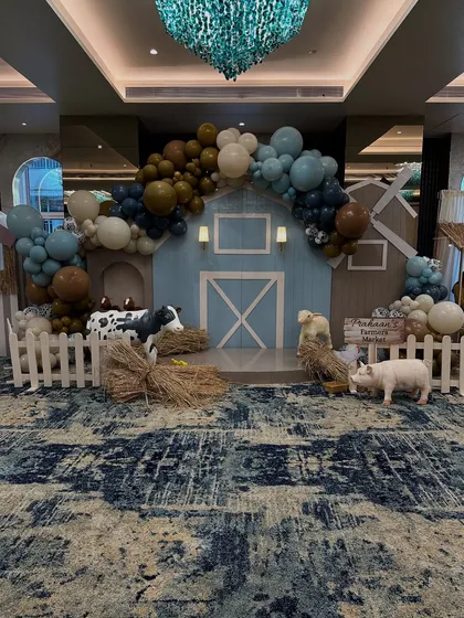 For Prahaan's second birthday, I brought a charming barnyard to life. This wide shot shows the complete farm-themed setup, featuring a custom-built barn backdrop, organic balloon garlands, and life-sized animal props that created an immersive experience for all the little guests.