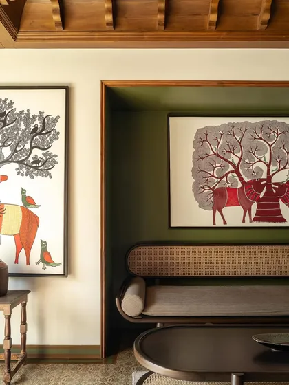 A detail of the lounge, where a large Gond painting of a tree is nestled into an alcove, creating a focal point.
