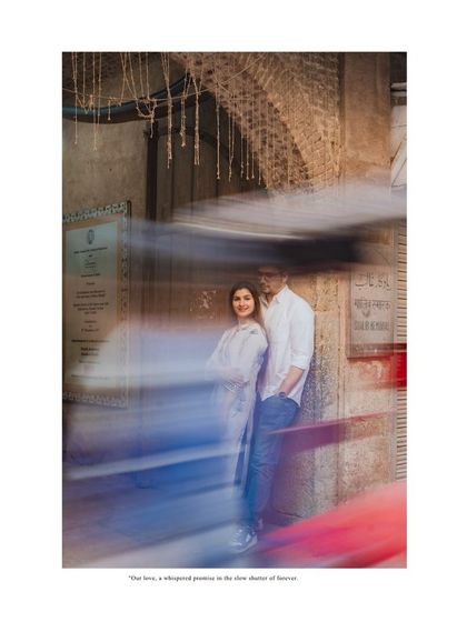 An artistic shot using slow shutter speed to create a sense of motion and stillness, with the couple as the calm center in a busy Delhi street.