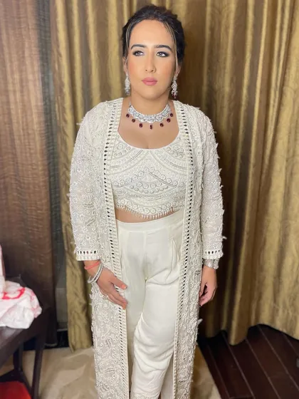 A full-length view of this chic and modern look. The clean, nude makeup is the perfect complement to her stylish outfit.