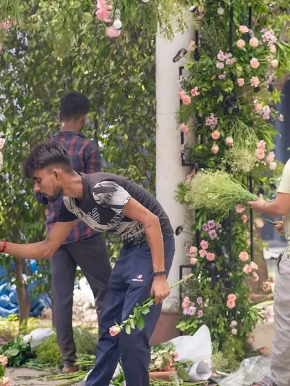 My team creating a floral arch on-site. This hands-on process ensures that every flower is perfectly placed.