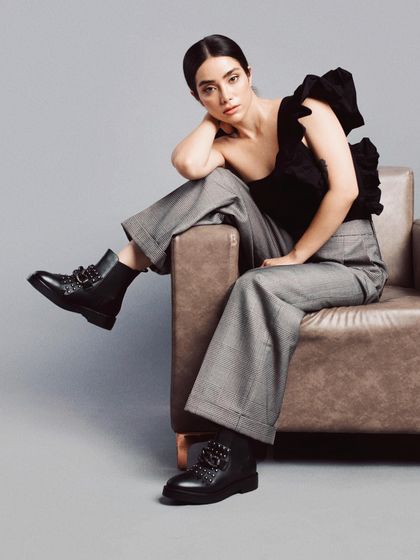 Styling for a shoe brand's lookbook, featuring buckled black combat boots. I paired them with wide-leg grey trousers and a one-shoulder top to create a look that is both tough and chic.