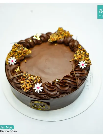 This is our Chocolate Almond Nougatine cake, offering a wonderful contrast of textures. The rich chocolate cake is decorated with crunchy clusters of caramelized almond nougatine.