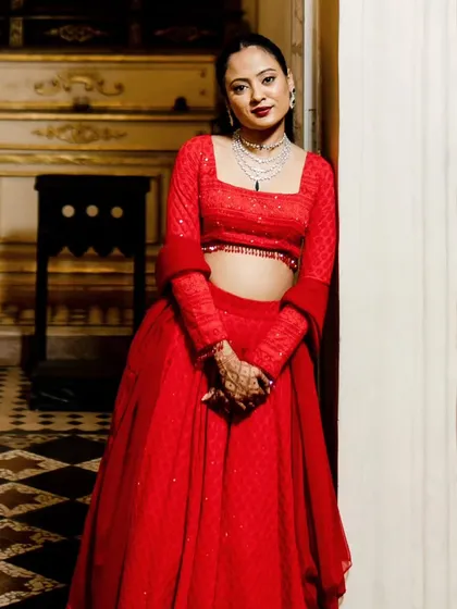A modern Sangeet look featuring a sleek high ponytail and a bold red lip. This style is chic, comfortable, and perfect for a bride who wants to dance the night away.