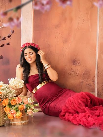 A beautiful solo shot of the mom-to-be relaxing in our rustic, warm-toned studio. The deep red gown and floral crown create a rich and romantic look.