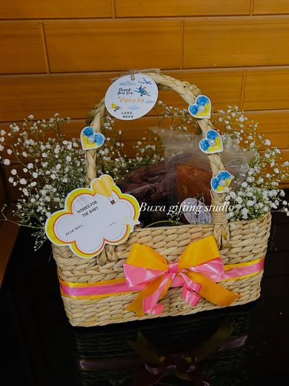 A simple yet elegant kauna grass basket, filled with baby's breath and decorated with a pink and yellow ribbon. This shows how a beautiful, eco-friendly basket can be the star of the gift.