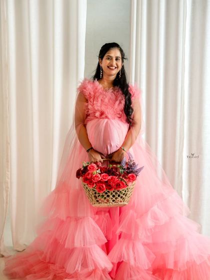A lovely studio portrait of an expecting mother in my pink tiered tulle gown. Using props like a flower basket can add a personal and charming touch to your photos.