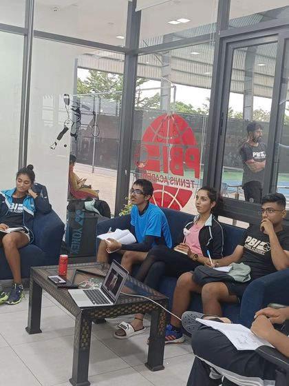 Another view of our athletes engaged in a mental conditioning workshop, taking notes and participating in discussions.