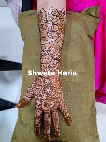 The other arm of a heavy Indian design, showing a consistent theme with slight variations. The pattern is rich with floral work, peacock details, and fine line fillers.