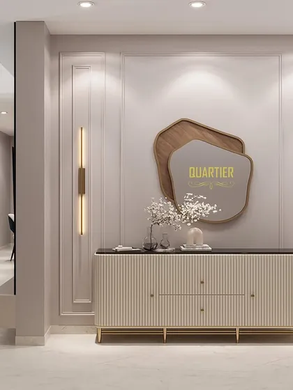 The foyer design for the Apex D'Rio project features a designer console with a fluted pattern and an abstract-shaped mirror. The wall is detailed with classic European moulding, creating a grand and sophisticated entrance.