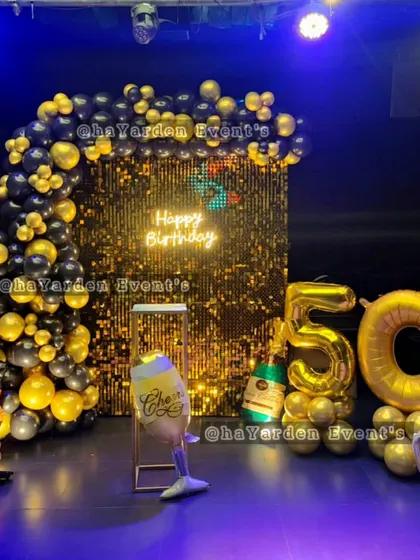 Let's get the party started for a 50th birthday. This setup brings a nightclub vibe with a gold sequin backdrop, a bold black and gold balloon arch, and large foil numbers. I also added fun props like beer and champagne bottle balloons to match the celebratory mood.