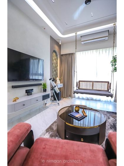 The 'Atmosphere' project living room features a comfortable swing, a floral sofa, and modern art. It’s a perfect example of how we create eclectic, personalized spaces that reflect the homeowner's personality.