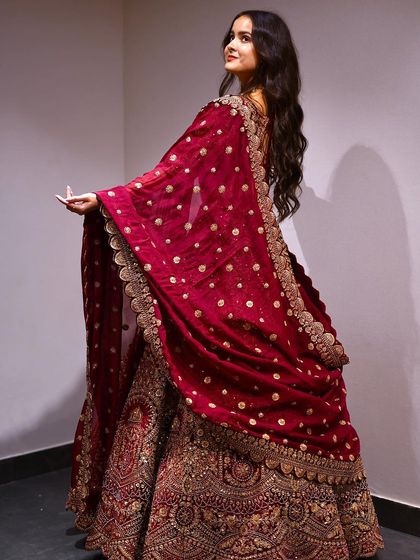The back of this maroon bridal lehenga is just as stunning as the front, with a beautifully draped dupatta covered in delicate gold work. Every angle is a picture-perfect moment.