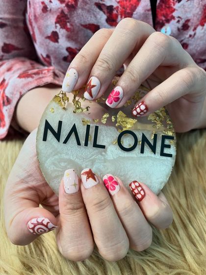 A fun, mismatched set featuring a variety of patterns in a red and pink color scheme. We combined stars, flowers, and geometric grids for a playful and eclectic manicure.