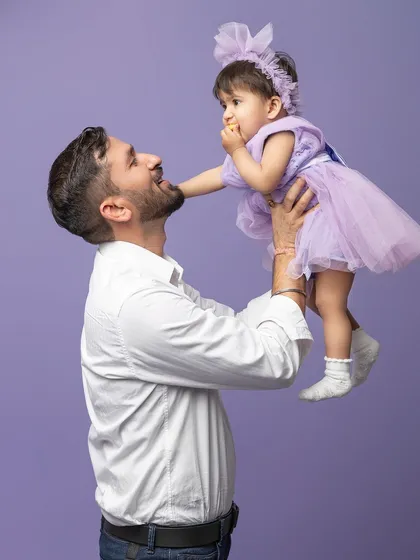 A father lifts his daughter up, and she looks down at him with pure adoration. These are the fleeting moments of childhood I feel so privileged to capture.