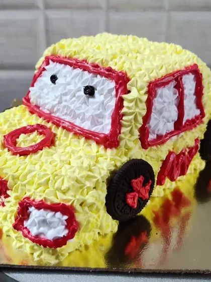A custom car-shaped cake, perfect for a young automobile enthusiast. This cake is decorated with yellow buttercream and uses Oreo cookies for wheels.