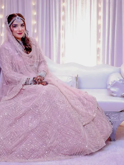 The bride seated on the stage, looking absolutely regal. The soft lighting and background add to the dreamy feel.