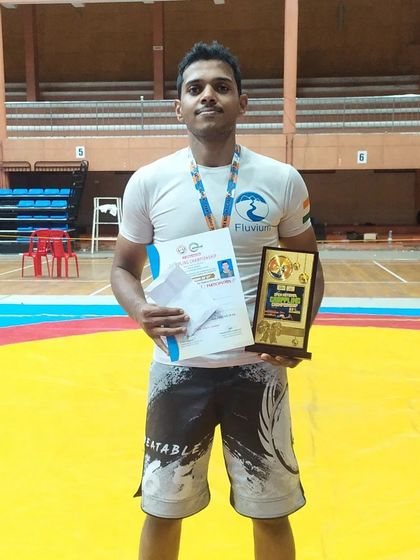 Standing on the mat with my Gold medal and certificate at the Kerala Open National Grappling Championship. It was a great event with tough opponents.