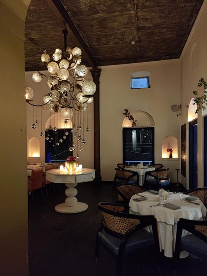 The warm glow from our custom chandeliers fills the room, creating an intimate and luxurious space. It’s an ambiance that invites you to linger and savor every moment.