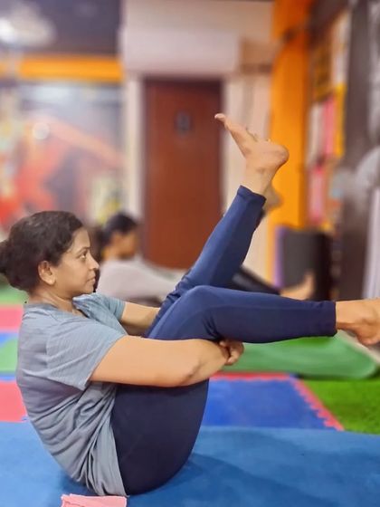 Hip-opening poses like this variation of boat pose are crucial for alleviating back pain and improving circulation, while also engaging the core.