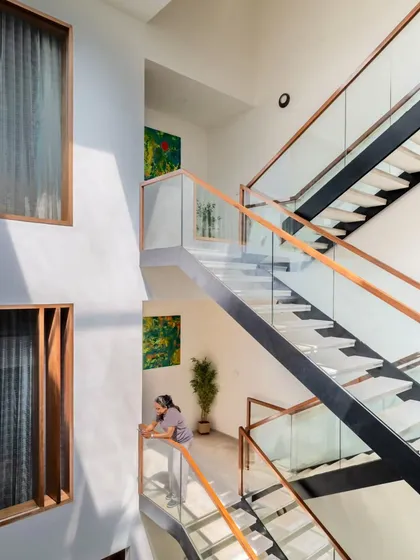 From this angle, you can see how the multi-level staircase interacts with the home's living spaces. The glass railings and open-riser design maintain a sense of lightness and visibility, ensuring the home feels connected across all its floors.