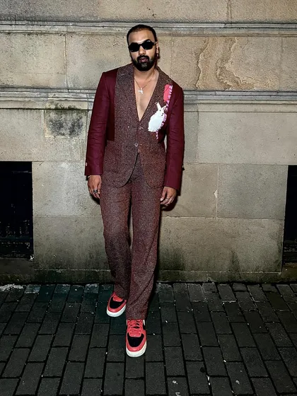 Arshad Ahmed elevates his style in the Phantasm Suit. Rich maroon linen, metal studs, and buckle loop trousers make for a truly unforgettable ensemble.
