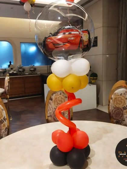 A creative table centerpiece for a 'Cars' party, featuring a character balloon inside a clear bubble balloon.