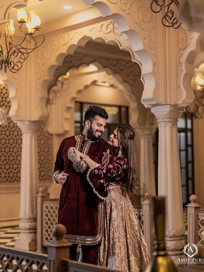 A playful and romantic moment captured under the elegant arches of a palace-style studio set. The rich velvet outfits and the grand architecture combine to create a feeling of modern royalty.
