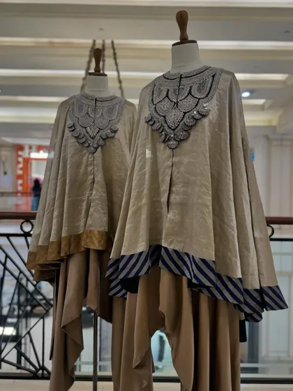 A display of umbrella kurta sets by Prisho, featuring layered silhouettes and heavily embellished yokes in a neutral beige palette.