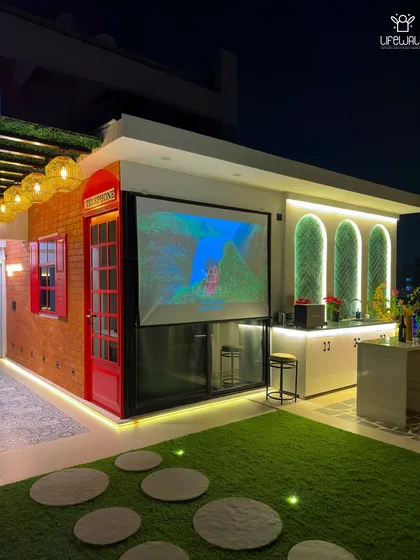 Your terrace can be your personal movie theater. This project features a retractable projector screen, a modern bar, and unique design elements like a classic red telephone booth, creating a one-of-a-kind entertainment zone.