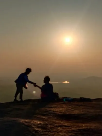 A silhouette of trekkers against the sunrise, one of them playing a guitar. We often have musical evenings and mornings.