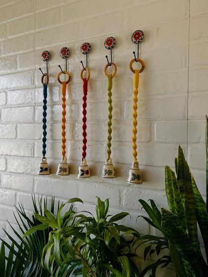 Our miniature macrame set of bells is now available in two variants. This image shows a set of five, with intricately knotted colorful cords and hand-painted ceramic bells, complete with matching ceramic hooks.