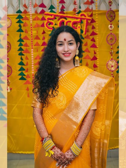 A simple and elegant portrait of the bride in a yellow saree for her haldi ceremony.