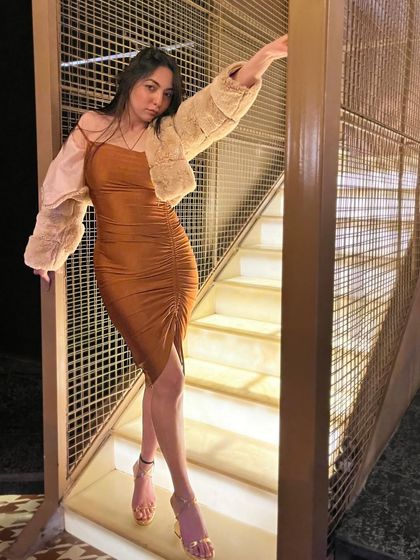 A confident, full-length shot of the brown dress and fur jacket, perfect for a winter party lookbook.