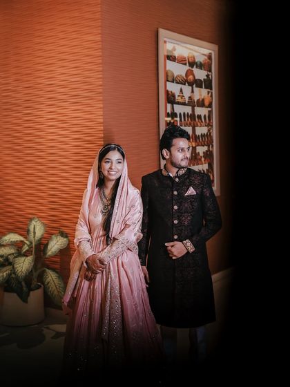 A beautifully lit portrait of a couple dressed in elegant attire for their engagement ceremony, capturing a moment of quiet happiness.