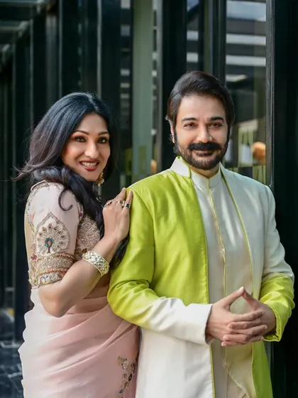 A candid moment between Prosenjit Chatterjee and Rituparna Sengupta from their Anandalok cover shoot. This image captures a natural interaction, adding a personal touch to the magazine feature.