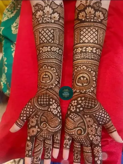 This design features a central mandala on the palm with peacock motifs, and traditional patterns extending up the arm.