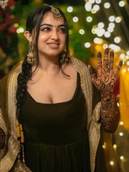 Another beautiful shot of a client at her mehndi ceremony, with fairy lights creating a magical backdrop.